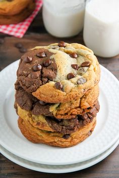 a stack of chocolate chip cookies sitting on top of a white plate next to a glass of milk