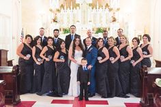 a group of people standing next to each other in front of a church pews