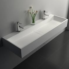 a white sink sitting next to two faucets in a bathroom