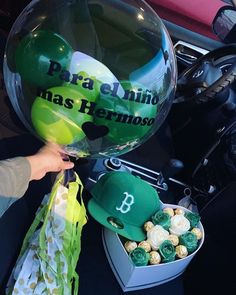 a person is holding a ballon and some candy in the back of a car