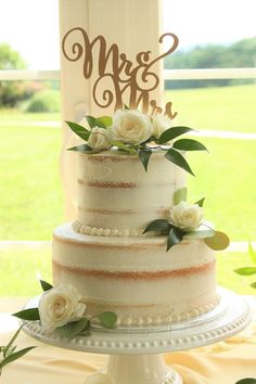 a wedding cake sitting on top of a table next to a sign that says mr and mrs