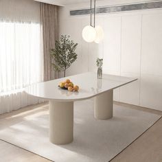 a white table with fruit on it in front of a curtained wall and window