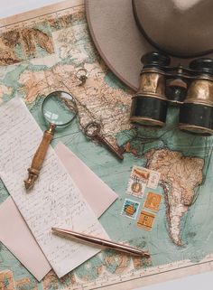 a map, magnifying glass, pen, and other items on top of it