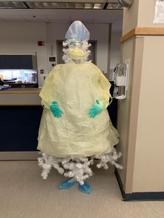 an inflatable person is standing next to a door wearing protective clothing and gloves