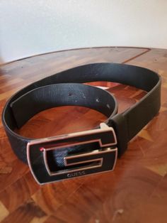 This listing is for a black polyurethane size 30 belt made by "GUESS". It is wide and textured black on top side with a black enamel buckle. The belt is in excellent condition and will arrive in a gift box.  Size: 30 Measures: From tip of buckle to end 38"L X 1 1/2"W Material: Black Polyurethane, black enamel, silver tone metal buckle Hallmark: GUESS 64726 30 Polyurethane Made in China Gift Box FREE SHIPPING Black Casual Belt With Buckle Closure, Casual Black Belt With Buckle Closure, Black Business Belts With Buckle Closure, Black Business Belt With Buckle Closure, Black Buckle Belts For Business, Black Belt With Buckle Closure, Big G, Suspender Belt, Black Enamel