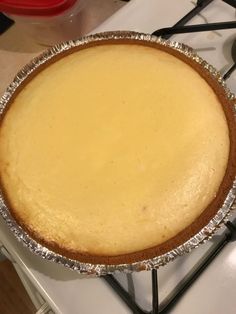 a pie sitting on top of a stove covered in tin foil