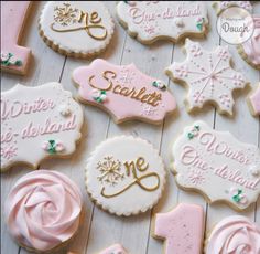 some decorated cookies with frosting on top of a white table and pink icing