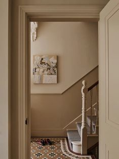 an open door leading to a hallway with tiled flooring and walls painted in beige