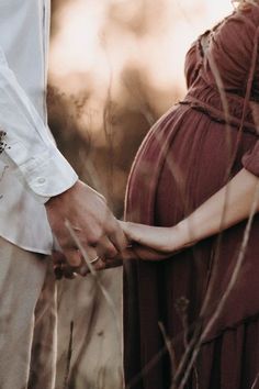 a pregnant woman holding her husband's hand