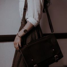 a woman carrying a brown leather briefcase