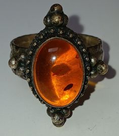 This ring took me through a most tumultuous time in my fabulous fifties  ( and going through an addiction to amber. It is size 7.5 and a serious statement ring. Downsizing my amber fetsh. Bo inside markings on this size 7 Very Boho looking statement ring. Minimal tarnish. No markings inside. Antique Orange Gemstone Jewelry, Antique Amber Cabochon Rings, Antique Oval Orange Jewelry, Oval Amber Jewelry, Oval Amber Cabochon Ring, Antique Orange Oval Jewelry, Vintage Orange Gemstone Jewelry, Amber Oval Cabochon Rings, Orange Oval Antique Jewelry