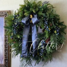 a christmas wreath hanging on the wall next to a painting