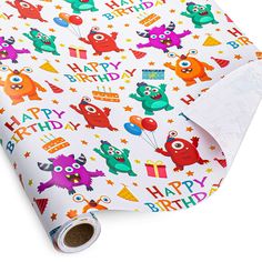 a birthday wrapping paper with monsters and balloons on it's side, next to a white background