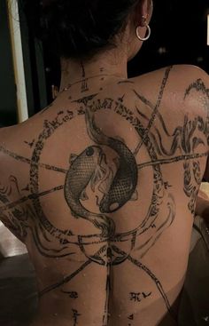 the back of a woman's body with tattoos on it