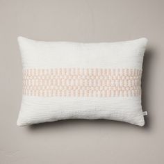 a white pillow with an orange stripe on the front and back, against a gray background