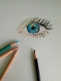 an eye with long eyelashes and two pencils next to it