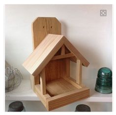 a wooden bird house sitting on top of a shelf