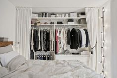 a bedroom with white walls and open closets