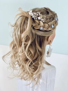 a woman with long blonde hair wearing a braid and flowers in it's hair