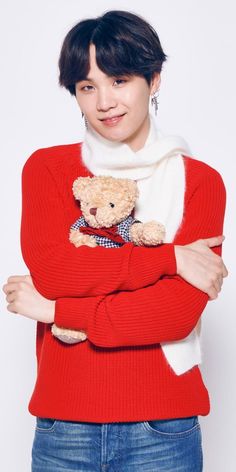 a woman in a red sweater holding a teddy bear