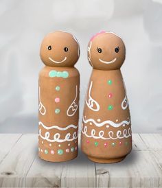 two wooden salt and pepper shakers with painted faces