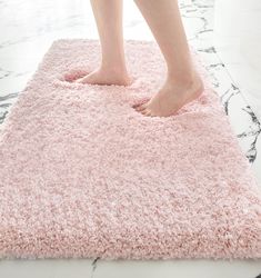 a person standing on top of a pink rug in the middle of a floor area