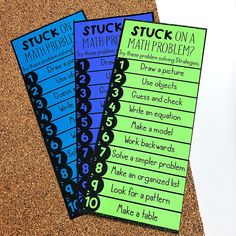 three stick on math problems cards sitting on top of a cork board