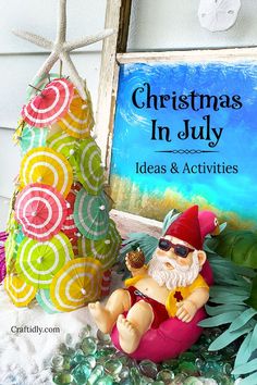 a christmas in july sign next to a gnome figurine