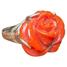 This is a 14K Yellow Gold and Coral Ring. It depicts a round hand carved dark Coral ring shaped as a large rose flower. The rose is mounted on 14kt yellow gold. Both upper shanks are engraved with a garland of leaves. Formal Rose Design Flower Ring, Luxury Elegant Coral Rings, Exquisite Yellow Gold Flower-shaped Jewelry, Luxury Coral Gemstone Ring, Die Rose, Hand-strung Round Red Coral Jewelry, Vintage Flower-shaped Rose Jewelry, Coral Ring, Ring Shapes