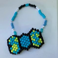 a blue and yellow beaded necklace on a white surface with beads around the neck