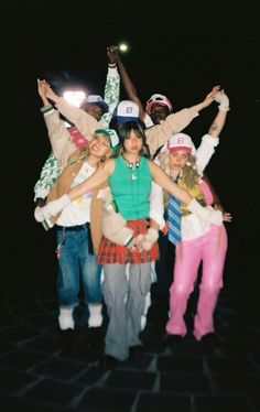 a group of young people standing next to each other with their arms in the air