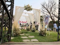 an outdoor ceremony with white drapes and flowers