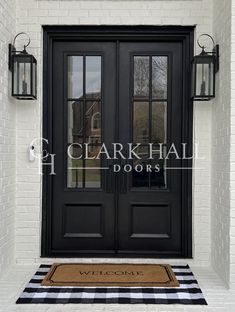 a black double door with two sidelights and a welcome mat