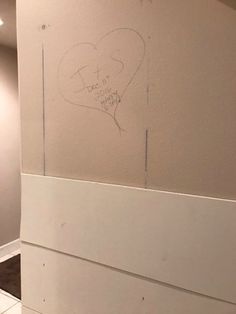 a white toilet sitting in a bathroom next to a wall with graffiti on it's side