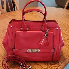 Coach Handbag In Immaculate Condition! Beautiful Red Color With Front Pocket And Detachable Shoulder Strap. Inside Has 3 Compartments With A Center Zip. Fabulous Addition To Your Collection. Will Add In Half Full Bottles Of Coach Cleaner And Moisturizer. 13.5 Inches Wide At Base. Red Satchel Bag With Branded Hardware, Red Rectangular Satchel With Silver-tone Hardware, Red Coach Shoulder Bag For Office, Coach Red Satchel With Detachable Handle, Coach Red Satchel With Detachable Strap, Red Satchel With Branded Hardware, Red Satchel With Silver-tone Hardware For Daily Use, Red Travel Satchel With Branded Hardware, Red Bag With Silver-tone Hardware For Daily Use