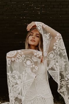 a woman wearing a white dress with sheer sleeves