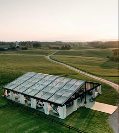 an aerial view of a glass house in the middle of a field