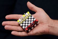 a person's hand holding a lego chess board ring