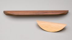 two pieces of wood sitting next to each other on a gray surface, one with a wooden edge and the other without