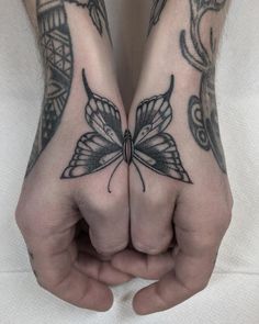 two hands with tattoos on them and one has a butterfly tattoo on the other hand