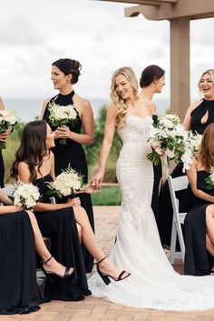 the bride and her bridesmaids are all dressed in black dresses with white bouquets