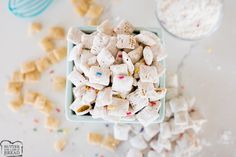 a bowl filled with marshmallows and sprinkles on top of a table