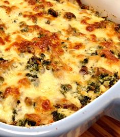 a casserole dish with cheese and spinach in it on a wooden table