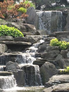 there is a large waterfall in the middle of this rock garden with lots of water