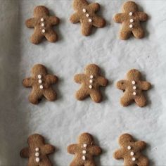 some cookies with white frosting are arranged on a sheet of paper