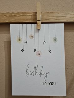 a birthday card hanging on a clothes line with the words happy birthday to you written in cursive writing