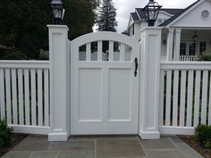 a white gate with two lights on each side