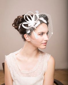 a woman wearing a veil with flowers on it's head and the caption reads, white fascination with black feathers