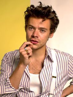 a young man poses with his hand on his chin