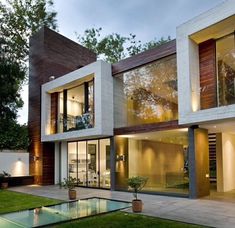 a modern house with large windows and grass